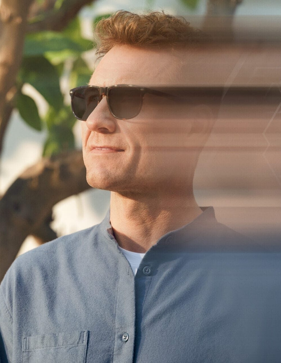 Mann mit Sonnenbrille schaut in die Ferne. 